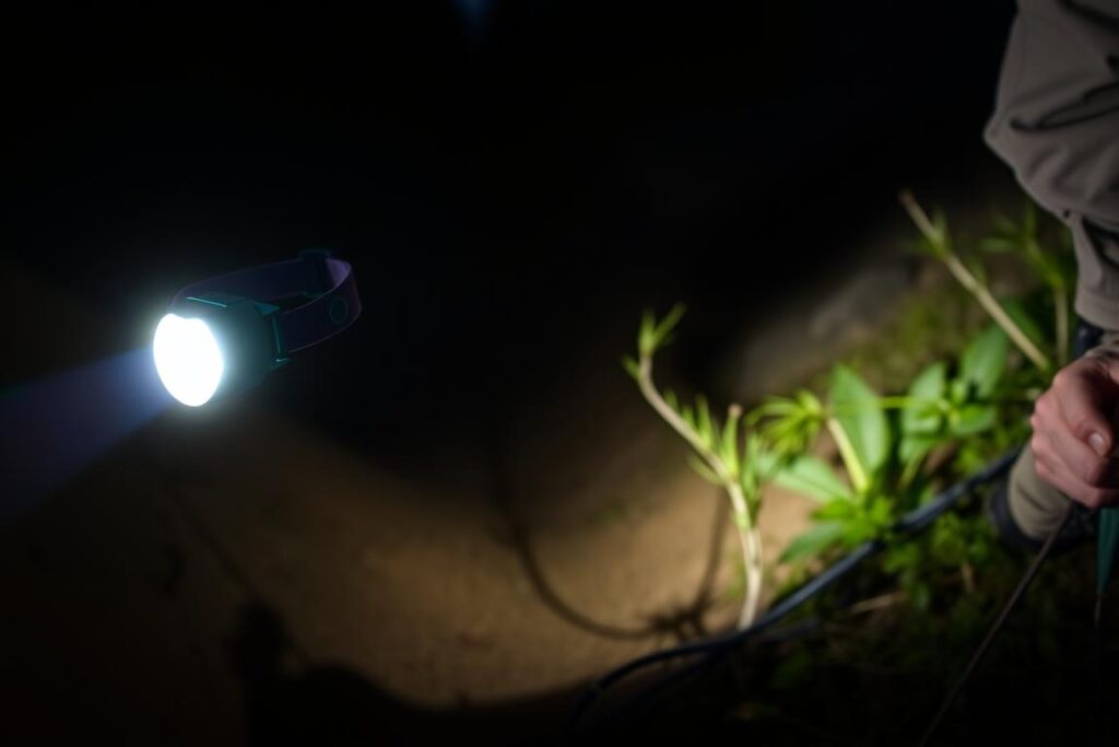 Lanterna de cabeça potente iluminando trilha noturna