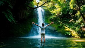 Pessoa de braços abertos embaixo de uma cachoeira, sentindo a água cair sobre o corpo